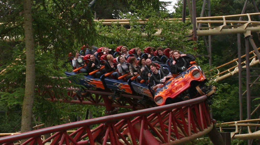 A full rollercoaster of people smiling as they go down the slope of the rails at Alton Towers theme park.